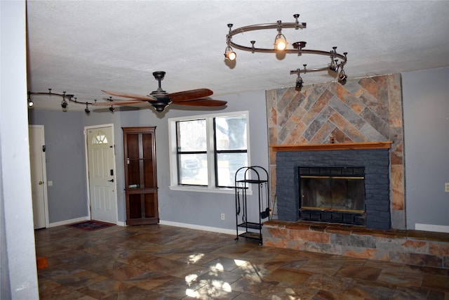 unfurnished living room with track lighting, a fireplace, and a textured ceiling