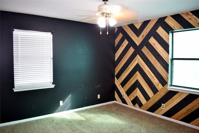 carpeted spare room with ceiling fan