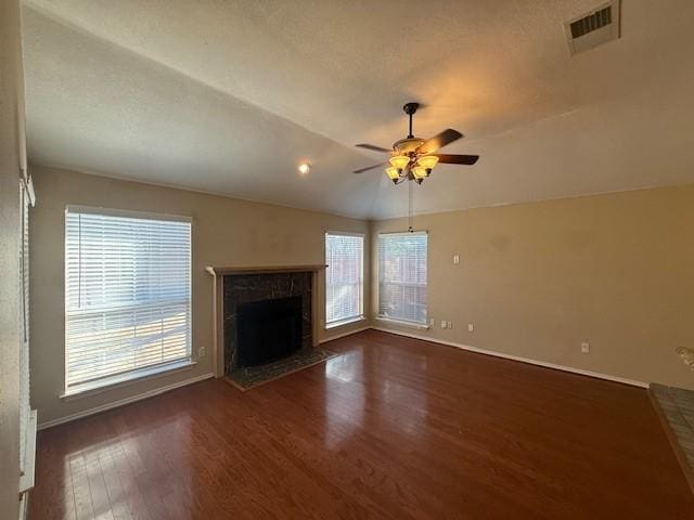 unfurnished living room featuring dark wood-type flooring, ceiling fan, lofted ceiling, and a fireplace