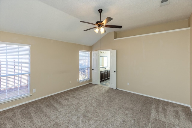 unfurnished room featuring visible vents, baseboards, ceiling fan, light colored carpet, and vaulted ceiling