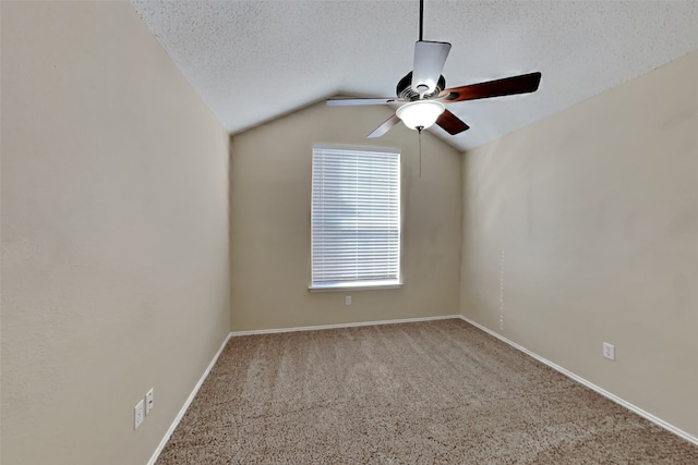 carpeted spare room with ceiling fan, lofted ceiling, baseboards, and a textured ceiling