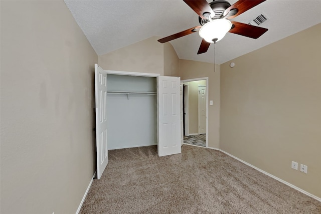 unfurnished bedroom featuring visible vents, a ceiling fan, a closet, carpet floors, and vaulted ceiling