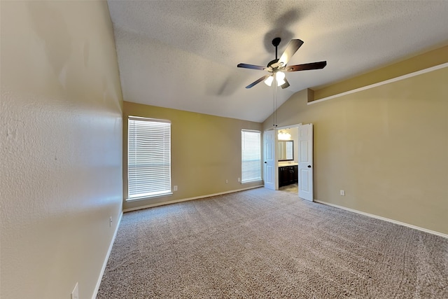 carpeted empty room with lofted ceiling, a textured ceiling, and ceiling fan