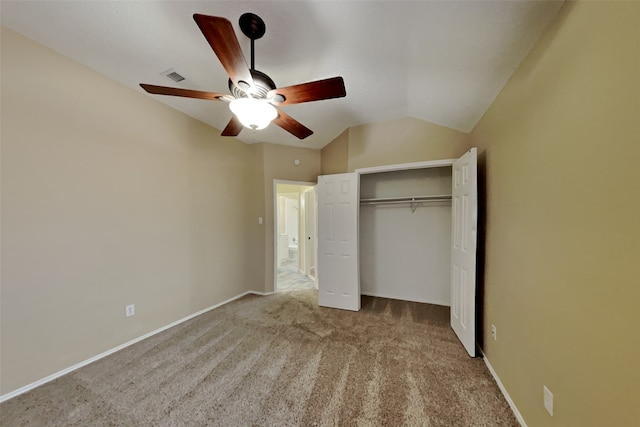 unfurnished bedroom with ceiling fan, a closet, vaulted ceiling, and light carpet