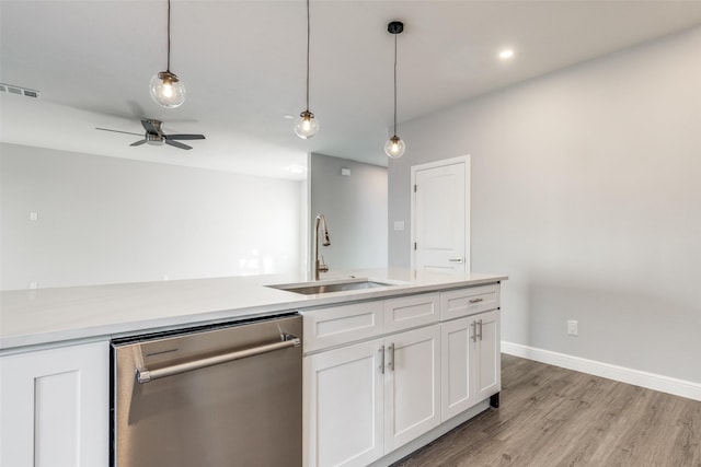 kitchen with sink, light hardwood / wood-style flooring, white cabinets, decorative light fixtures, and stainless steel dishwasher