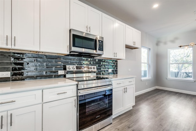 kitchen with backsplash, appliances with stainless steel finishes, and white cabinets