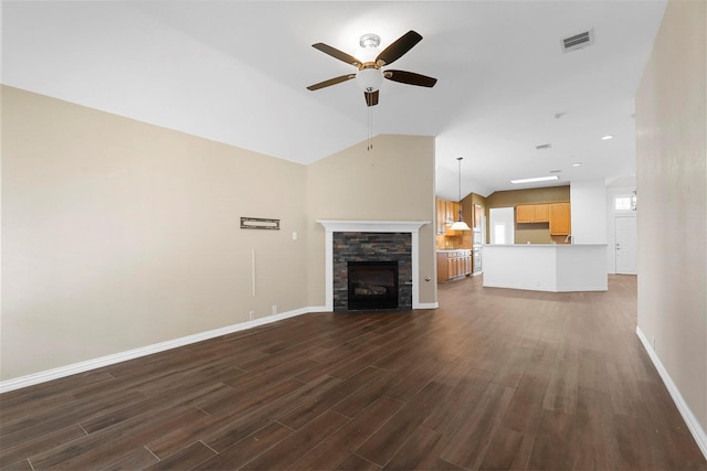 unfurnished living room featuring a fireplace, dark wood-type flooring, ceiling fan, and vaulted ceiling