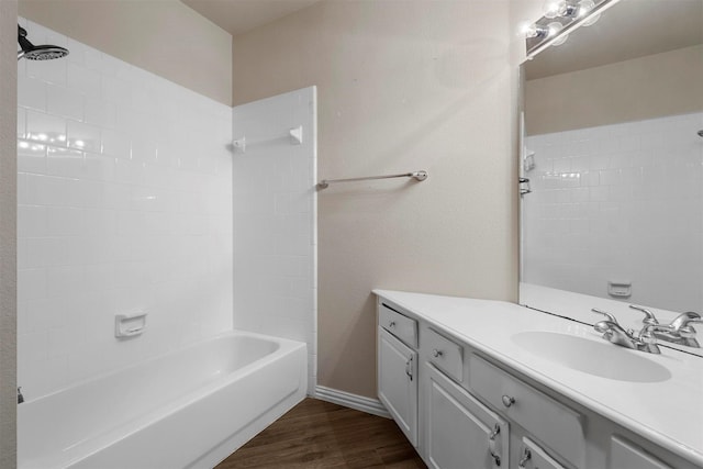 bathroom featuring hardwood / wood-style flooring, tiled shower / bath, and vanity