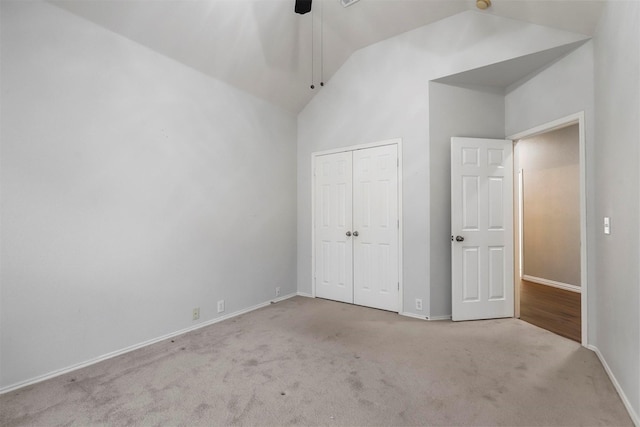 unfurnished bedroom with light carpet, vaulted ceiling, a closet, and ceiling fan