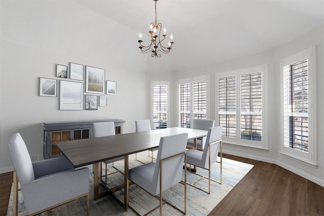 dining space with hardwood / wood-style flooring and an inviting chandelier