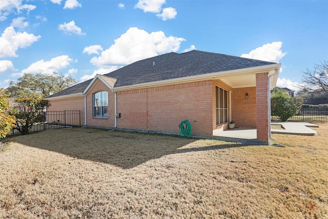 rear view of property with a patio and a lawn