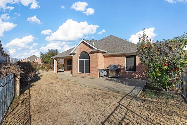 back of house featuring a patio area and a lawn