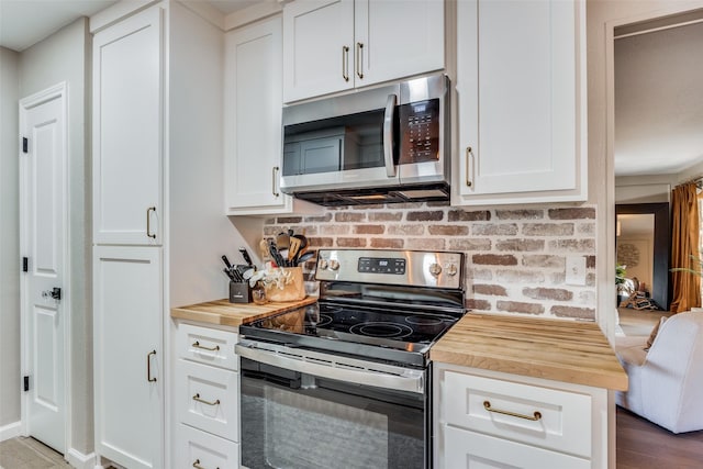 kitchen featuring stainless steel appliances, wooden counters, and white cabinets