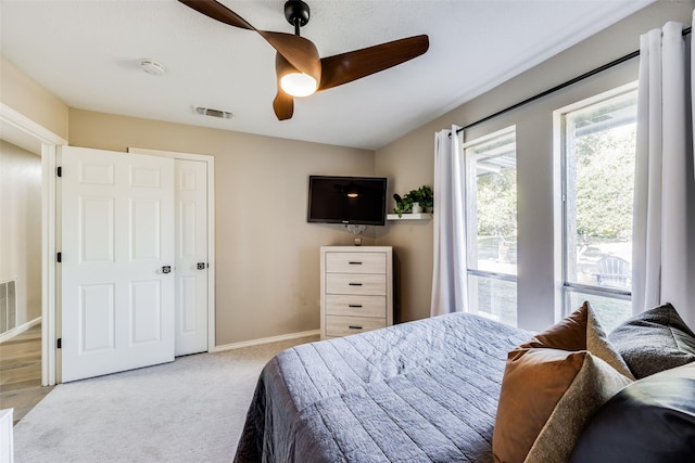 bedroom with ceiling fan and light carpet