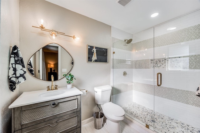 bathroom with vanity, toilet, a shower with shower door, and tile patterned flooring