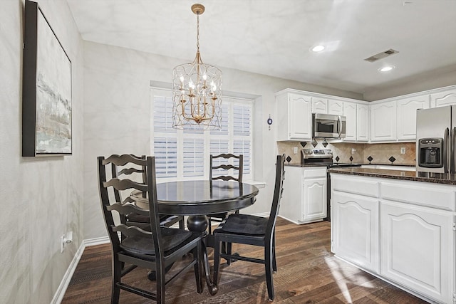 kitchen with pendant lighting, appliances with stainless steel finishes, dark hardwood / wood-style floors, and white cabinets