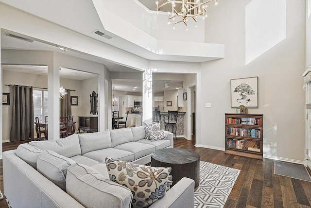 living room with dark hardwood / wood-style floors and a chandelier