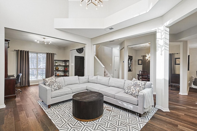 living room with hardwood / wood-style floors, a high ceiling, and a notable chandelier