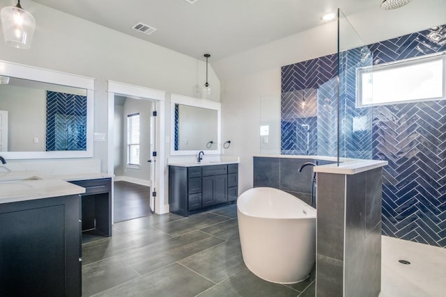 bathroom with vanity, tile walls, plus walk in shower, and a healthy amount of sunlight