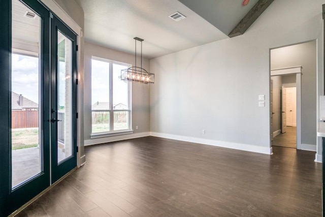 spare room with dark wood-type flooring, a chandelier, and french doors