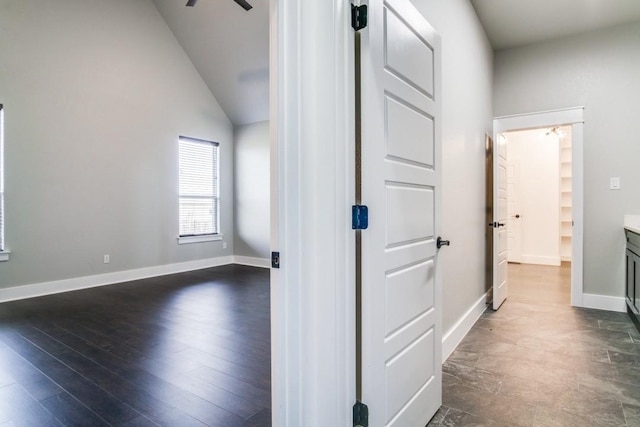 hall with dark wood-type flooring and high vaulted ceiling