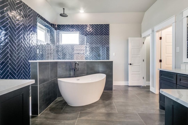 bathroom with tile patterned floors, vanity, independent shower and bath, and tile walls