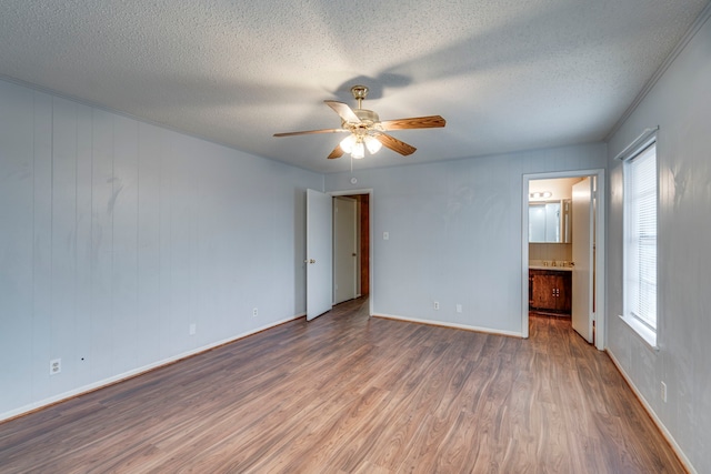 empty room with hardwood / wood-style flooring, a textured ceiling, and ceiling fan