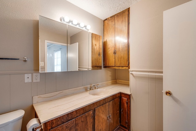 bathroom with vanity, a textured ceiling, and toilet