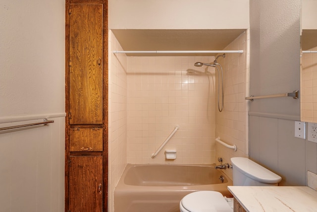 full bathroom featuring tiled shower / bath, vanity, and toilet