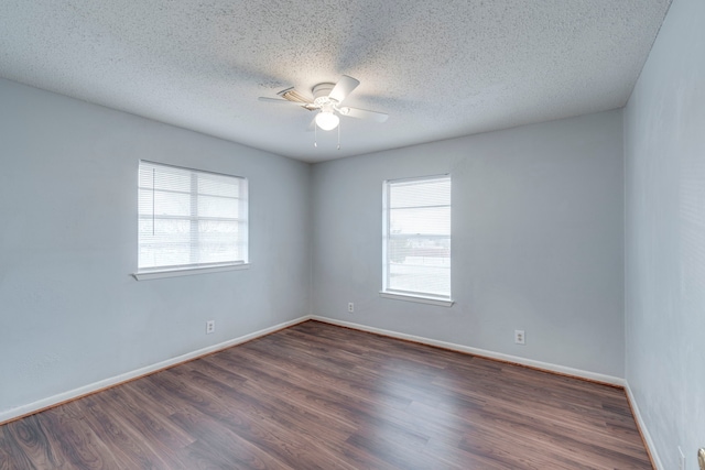 unfurnished room with a textured ceiling, dark wood-type flooring, and ceiling fan