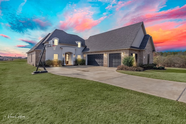 french provincial home with a garage and a lawn