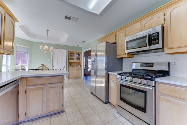 kitchen with a chandelier, light brown cabinets, a raised ceiling, pendant lighting, and stainless steel appliances