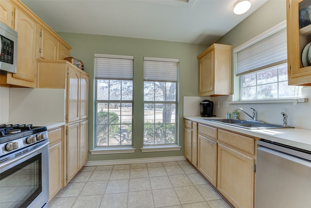 kitchen featuring appliances with stainless steel finishes, light brown cabinetry, and sink