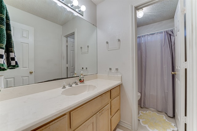 bathroom featuring walk in shower, vanity, toilet, and a textured ceiling