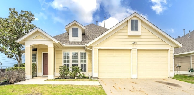 view of front of property featuring an attached garage, a shingled roof, and driveway