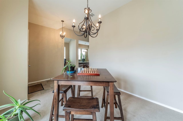 dining space with light colored carpet, baseboards, and a chandelier