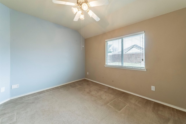 carpeted spare room featuring baseboards, a ceiling fan, and vaulted ceiling