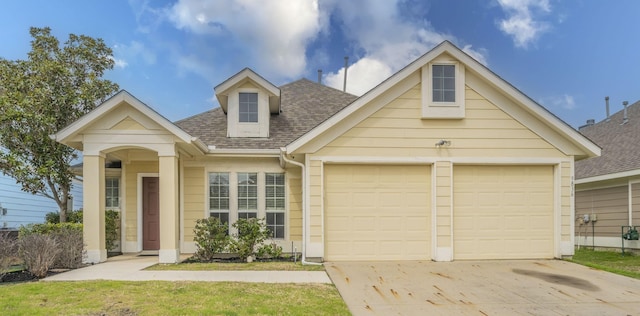 view of front facade featuring concrete driveway, an attached garage, and a shingled roof