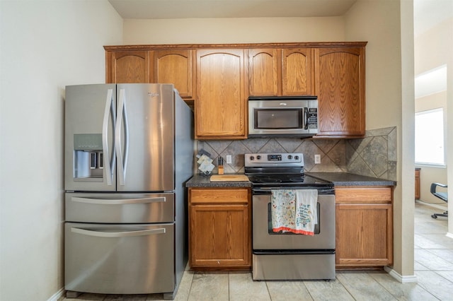 kitchen featuring dark countertops, backsplash, and appliances with stainless steel finishes