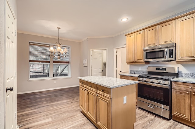 kitchen with light stone counters, crown molding, a center island, light wood-type flooring, and stainless steel appliances