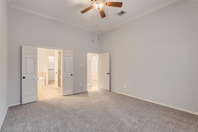 unfurnished bedroom with ornamental molding, light colored carpet, ceiling fan, and ensuite bathroom