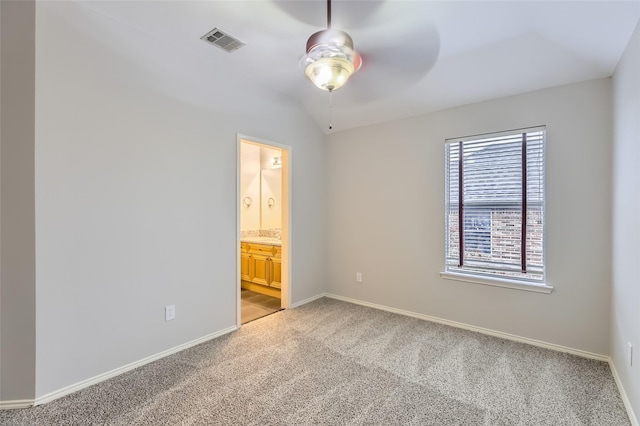 unfurnished bedroom with carpet floors, vaulted ceiling, ceiling fan, and ensuite bathroom