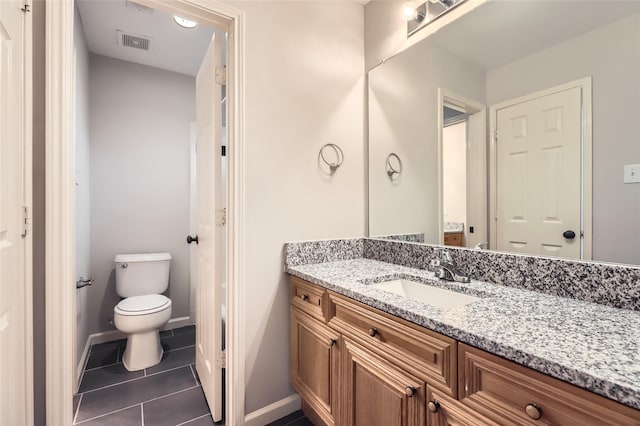 bathroom with tile patterned flooring, vanity, and toilet