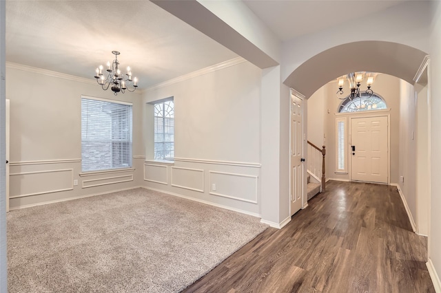 entrance foyer featuring crown molding, dark hardwood / wood-style floors, and a notable chandelier