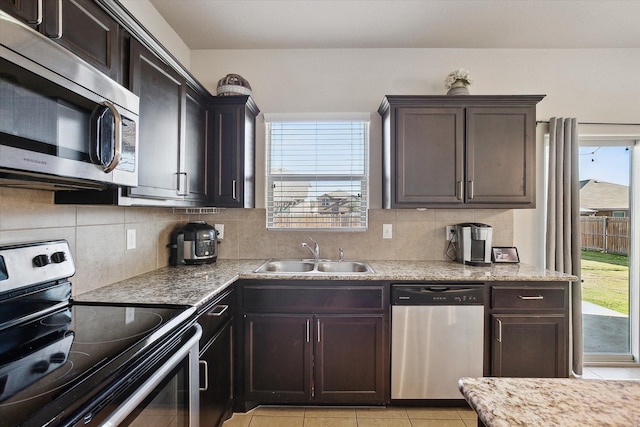 kitchen with stainless steel appliances, sink, dark brown cabinets, and backsplash