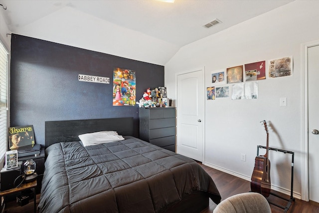 bedroom with lofted ceiling and dark hardwood / wood-style floors