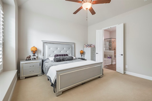 bedroom featuring light carpet, ceiling fan, and ensuite bath