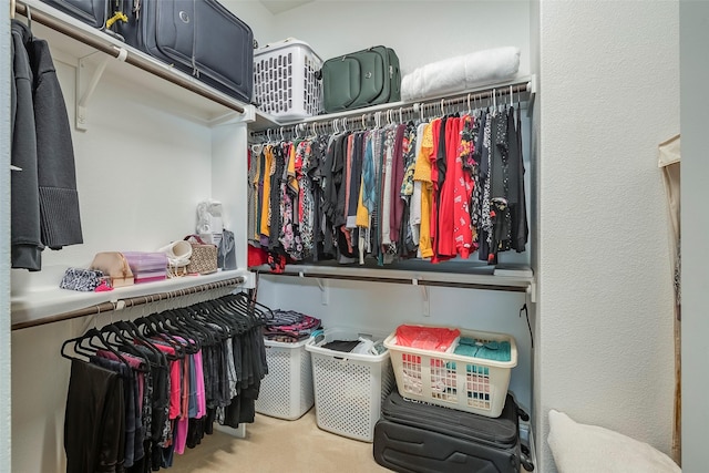 walk in closet featuring light colored carpet