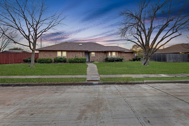 ranch-style home with a lawn