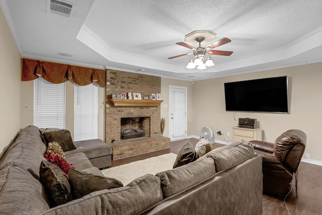 living room with crown molding, a raised ceiling, and a textured ceiling